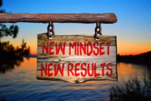 New mindset new results motivational phrase sign on old wood with blurred background